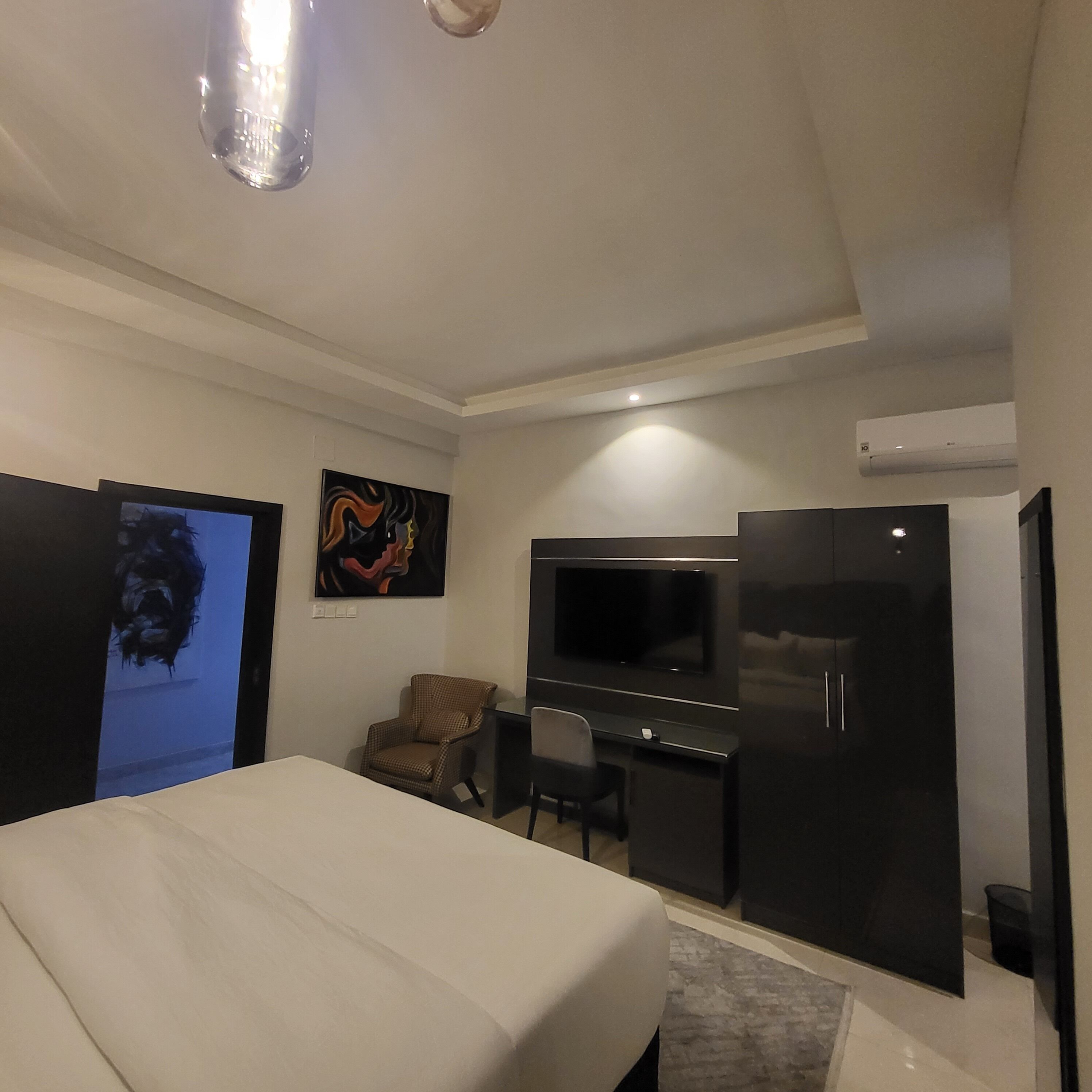 Une chambre d’hôtel équipée d’un lit, d’un bureau, d’une chaise, d’une télévision et d’un appareil de climatisation.