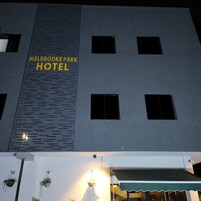 Fachada del Hotel Melbroke Park, de diseño moderno, con un letrero llamativo y varias ventanas.