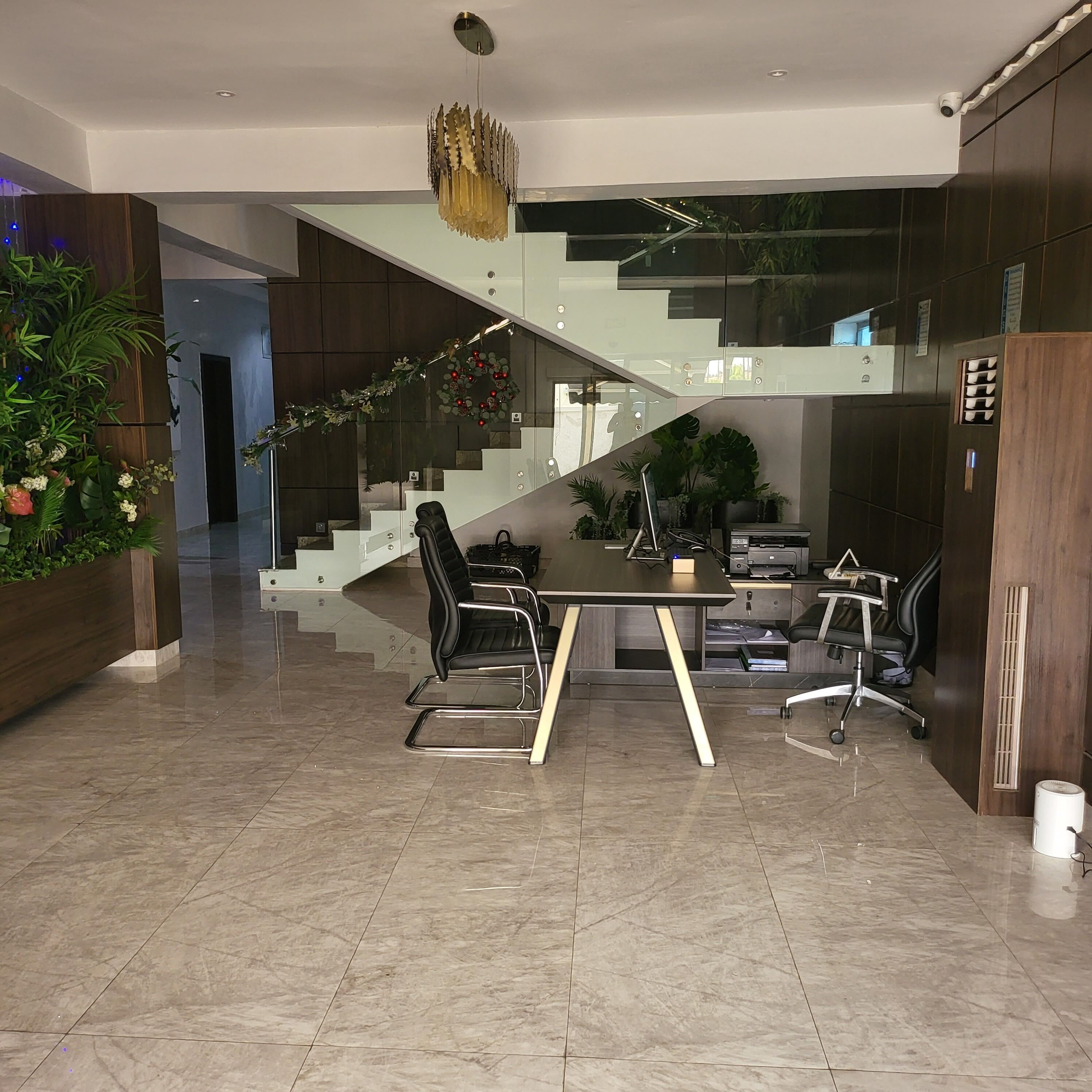A modern office space with a glass staircase, a conference table, and office chairs.