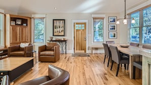 A spacious living room with a wooden floor, leather furniture, and large windows. - The French St Retreat 4 Bedroom Home by RedAwning (Breckenridge)