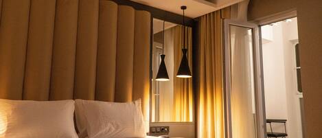 A hotel room with a large bed, a mirror, and a view of the hallway.