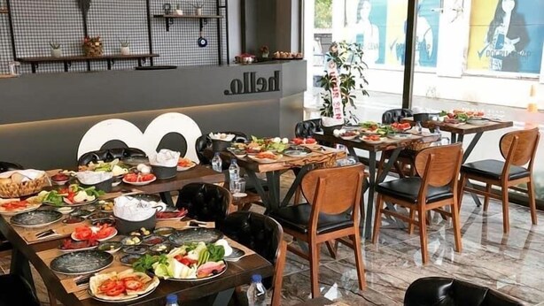 Un ristorante con diversi tavoli apparecchiati, che offre una varietà di piatti e bevande.