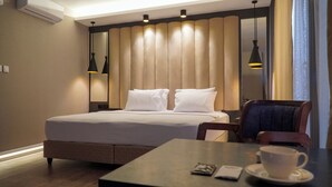 Una camera d'albergo con un letto, un tavolo con una tazza e un telefono, e una sedia.