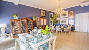 Un salon comprenant un canapé, des fauteuils, une table basse et une bibliothèque.