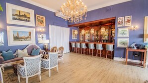 Une pièce dotée d’un coin bar, d’un plancher en bois et d’un lustre.