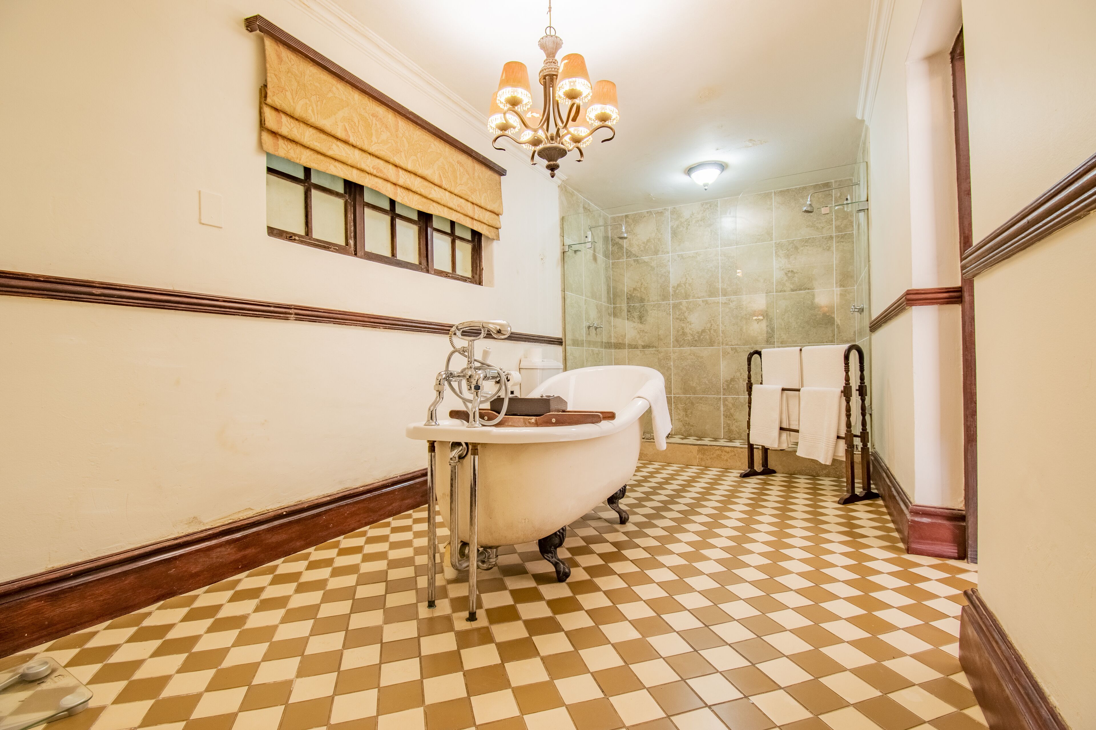 A bathroom with a clawfoot bathtub, a sink, and a shower enclosure.