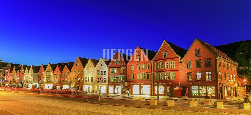 A row of traditional European-style buildings with signage for various shops and businesses.