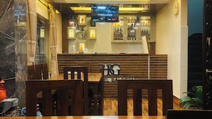 Un restaurant doté d’un bar, de meubles en bois et d’un écran de télévision diffusant des « films à suspense ».