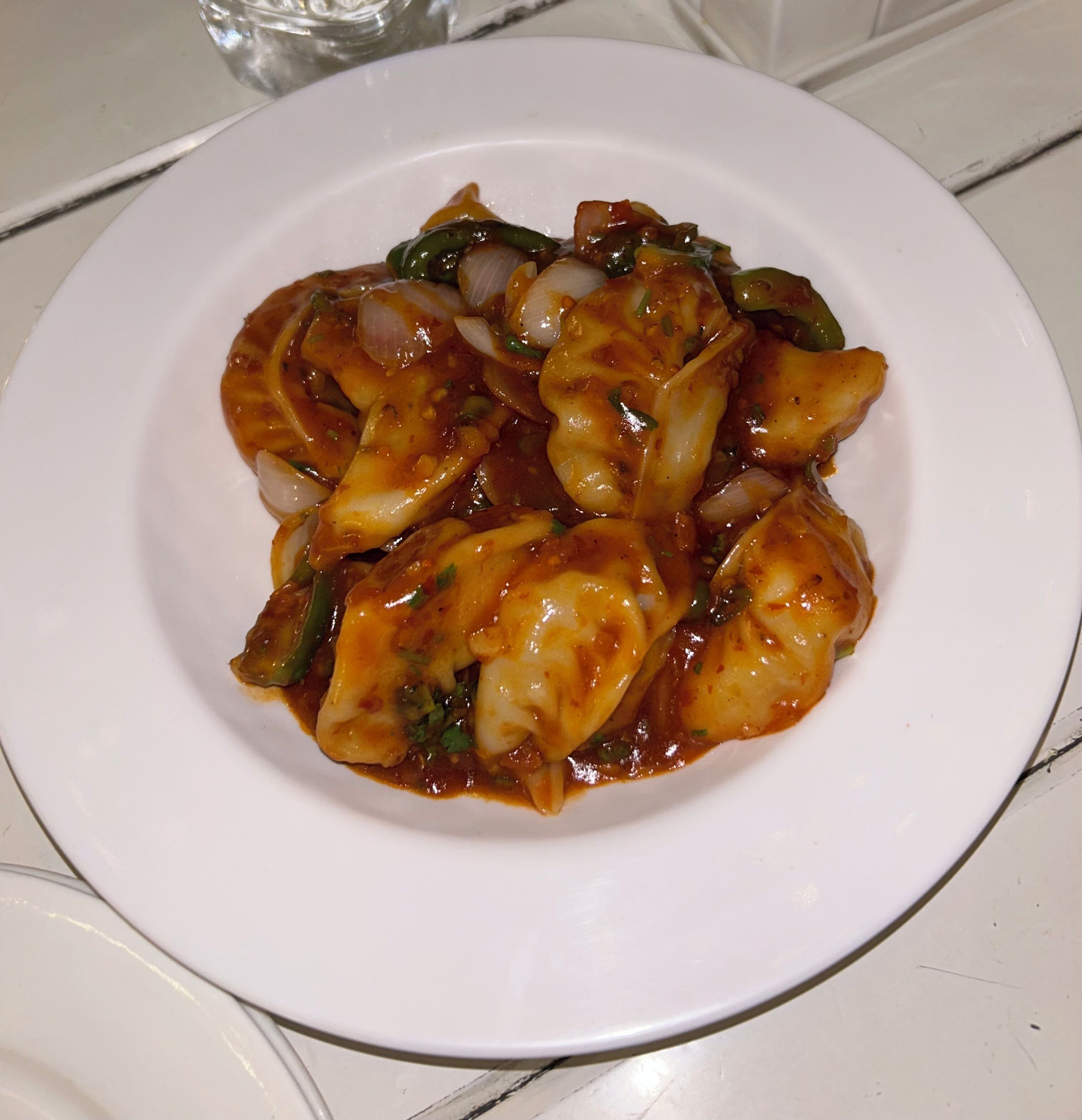 A plate of food with a white plate on a tiled surface.