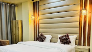 Une chambre à coucher moderne avec un grand lit, une tête de lit en bois et des lampes de chevet.