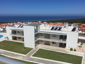 A modern building with multiple balconies and solar panels.