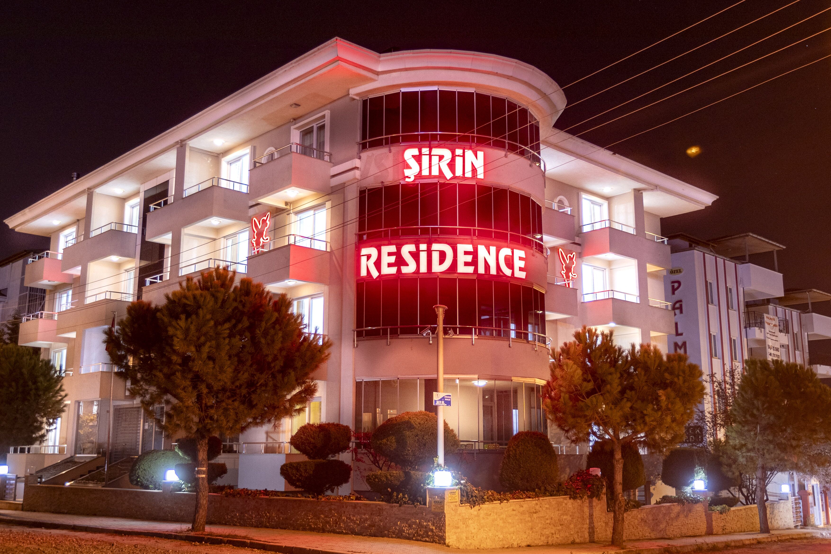 A modern building with a prominent sign reading "Sirin Residence."