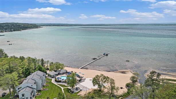 Une propriété située sur la côte, dotée d’une piscine, d’une plage et d’une jetée qui s’avance dans l’eau.