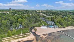 Vue aérienne d’un complexe hôtelier doté d’une plage, d’une piscine et d’une route menant aux bâtiments.