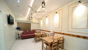 Un comedor moderno con una mesa y sillas de madera, un sofá rojo y un ventilador de techo.
