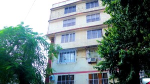 Un edificio de varios pisos con balcones y unidades de aire acondicionado.