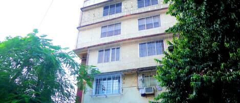 Un edificio de varios pisos con balcones y unidades de aire acondicionado.