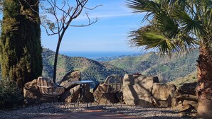 A terrace with wicker chairs and a table overlooking a coastal landscape. - Casa El Mirador Offers Spectacular Views, Comfort, and a Heated Pool (arenas)