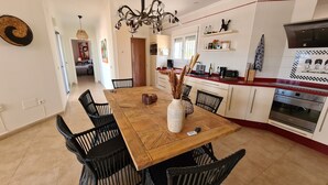 A modern kitchen with white cabinets, a red countertop, and a built-in oven. - Casa El Mirador Offers Spectacular Views, Comfort, and a Heated Pool (arenas)