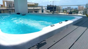 A rooftop swimming pool with a clear view of the cityscape in the background. - Luxury in Naco 2BR: Pools, gym, views, bars and more (Santo Domingo)