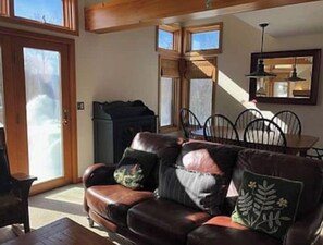 A cozy living room with a leather sofa, a dining table with chairs, and a fireplace. - 4 Season Spyglass Townhouse on Haystack Golf Course
Ski/Board/Golf/Hike/Relax (Wilmington)