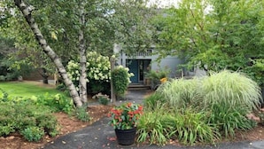 A garden pathway leading to a house with a front door, surrounded by various plants and trees. - 4 Season Spyglass Townhouse on Haystack Golf Course
Ski/Board/Golf/Hike/Relax (Wilmington)