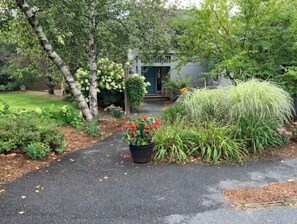 A garden pathway leading to a house with a front door, surrounded by various plants and trees. - 4 Season Spyglass Townhouse on Haystack Golf Course
Ski/Board/Golf/Hike/Relax (Wilmington)