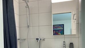 Ein modernes Badezimmer mit Dusche, Toilette und Waschbecken.