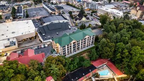 An aerial view of a hotel with multiple buildings, parking areas, and surrounding greenery. - Downtown Gatlinburg Condo | Walk to Attractions! (Gatlinburg)