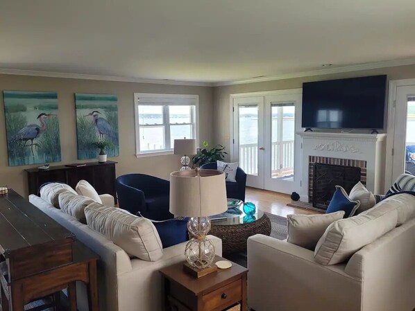 A living room with a sofa set, a coffee table, a lamp, and a fireplace. - High Water Guest House<br> (Cambridge)