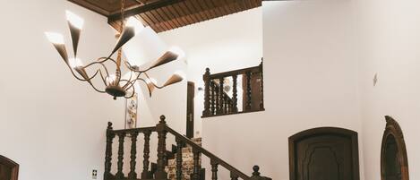 A wooden staircase with a marble floor leading to a door.