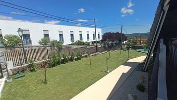 A residential area with a white building, a fenced yard, and a clear sky.