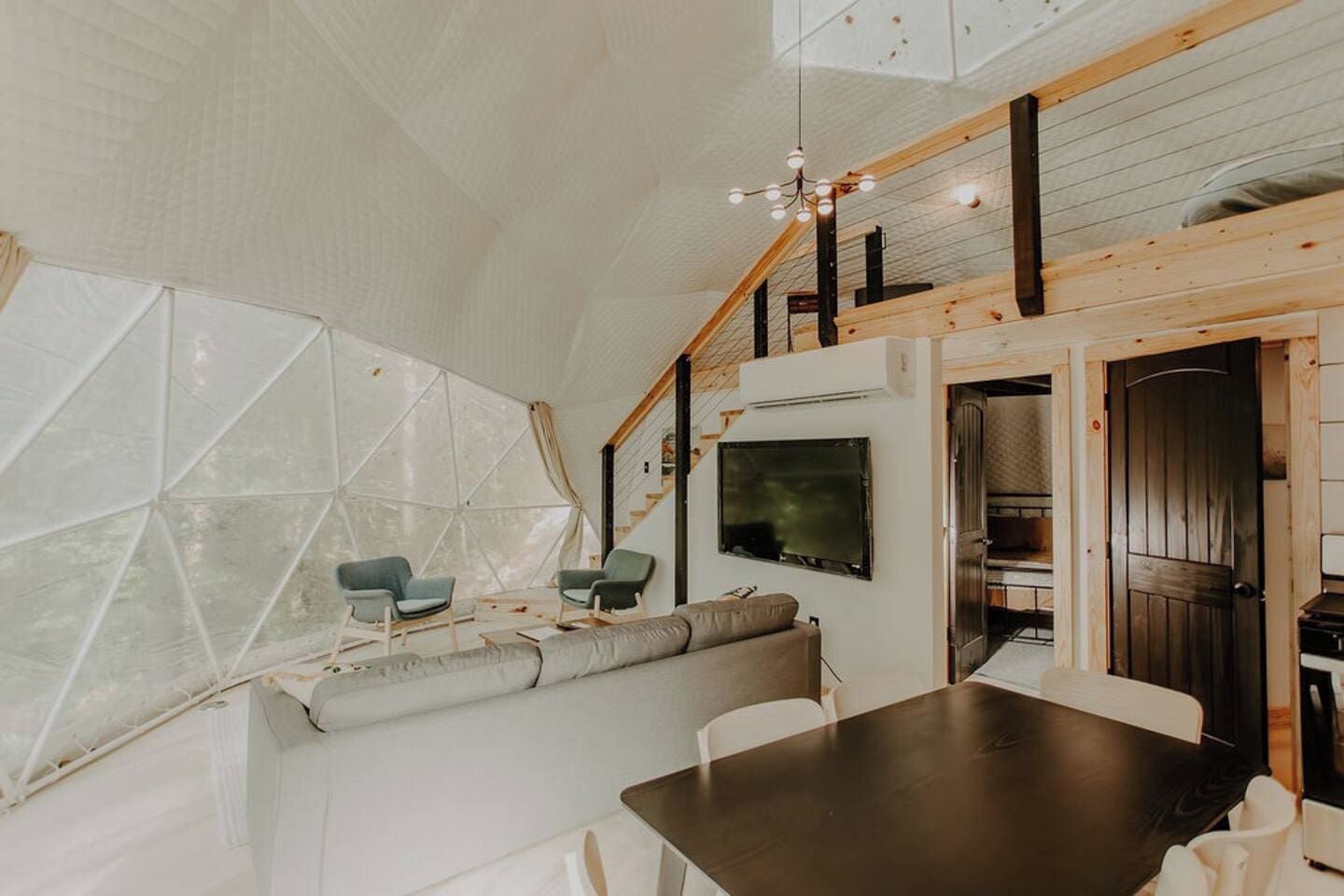 Ein modernes Interieur mit Essbereich, Sitzgelegenheiten und einer Treppe.