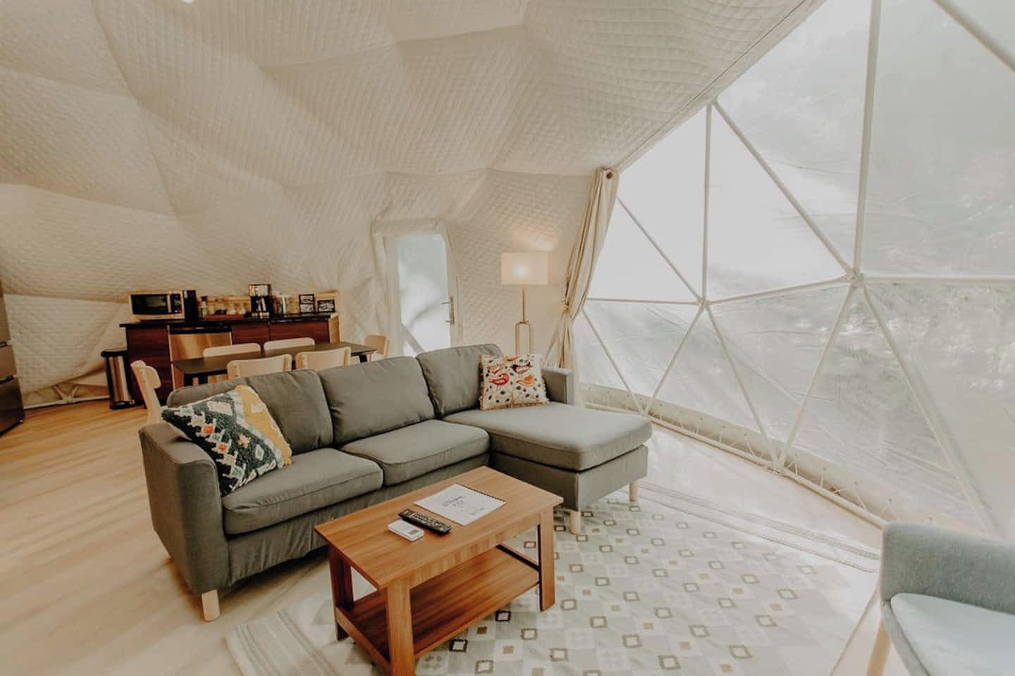 A cozy living area with a sofa, a coffee table, and a dining table with chairs.