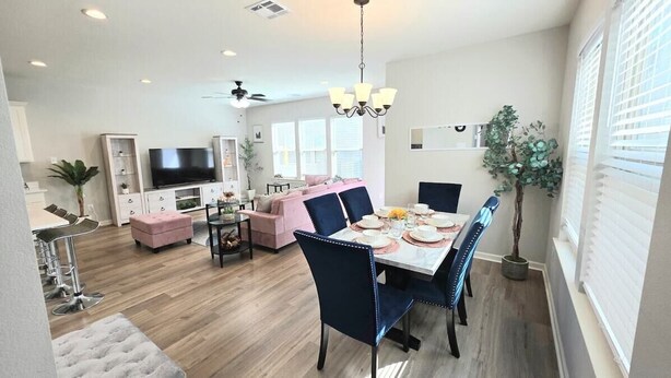 A modern living room with a dining area, a TV, and a ceiling fan. - Mardi Gras Magic Getaway in Baton Rouge  -  BC1019 (Baton Rouge)