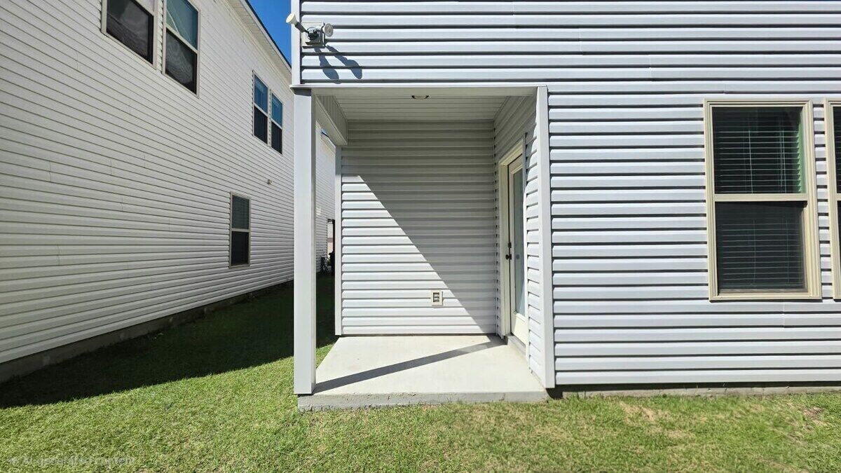 Un edificio residenziale a un piano con veranda e porta garage.