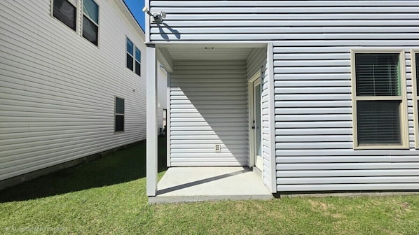 A single-story residential building with a front porch and a garage door.