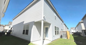 A residential building with a covered porch, a garage, and a small front yard.