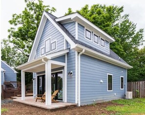 A two-story house with a covered porch and a small deck. - Private Sunny Cottage with King Bed + Yard / Patio (Arlington)