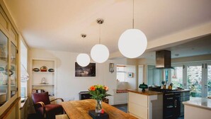 A modern kitchen with a wooden island, pendant lights, and a view to the outdoors. - TCN · The Crow's Nest, Pittenweem - Your Seaside Retreat (Pittenweem, Fife,)