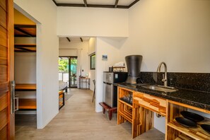 A modern kitchen with a black granite countertop, stainless steel appliances, and wooden cabinetry.