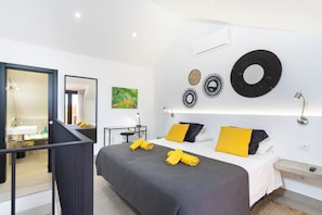 A modern bedroom with a bed, bedside tables, a mirror, and wall decor.