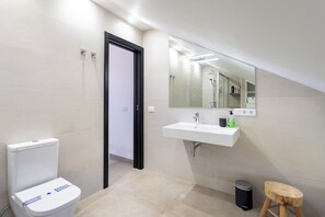 A modern bathroom with a toilet, sink, mirror, and a small stool. - Home2Book Modern Design Seaview Apt, Pool&Terrace (Playa de la Américas)