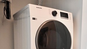 Zwei übereinandergestellte Samsung Waschmaschinen mit Frontlader in einem Waschraum.