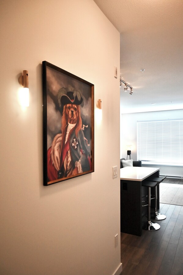 Ein modernes Interieur mit Essbereich, einem Gemälde an der Wand und einem Fenster mit Jalousien.