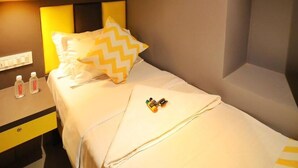 A hotel room with a bed, a bedside table with a lamp, and a ceiling fan. - CABINSTAY MAROL- THE HUBZ (Mumbai)