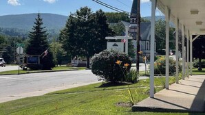 A roadside motel with a covered porch, a mountain backdrop, and a signboard. - Updated Main St Condo in downtown Ludlow! (Ludlow)