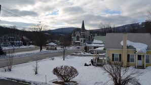Un quartier résidentiel enneigé, avec une église, des maisons et une route.