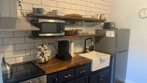 Une cuisine compacte équipée d’un four à micro-ondes, d’une cuisinière et d’un évier.
