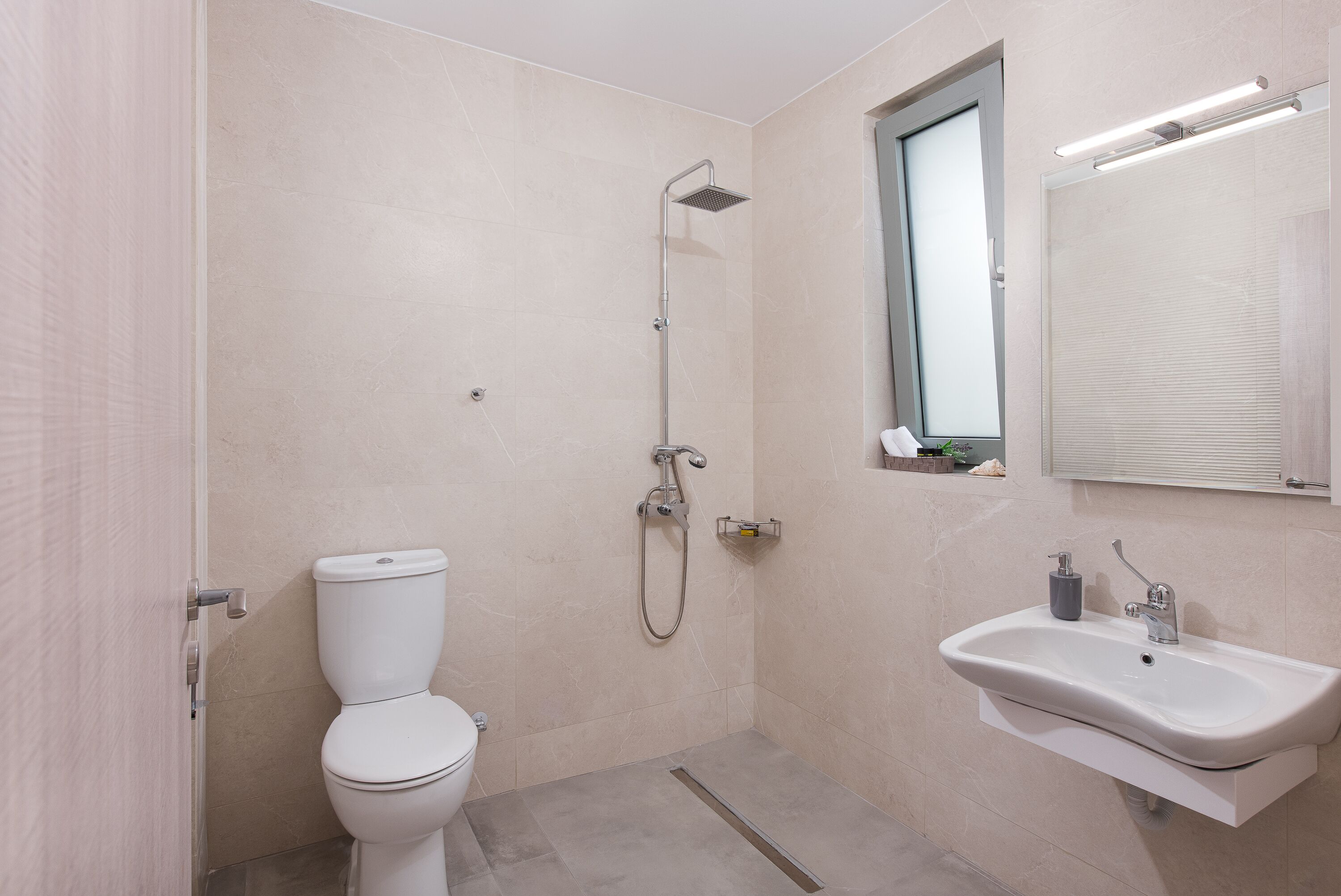 A bathroom with a toilet, a shower, and a sink.